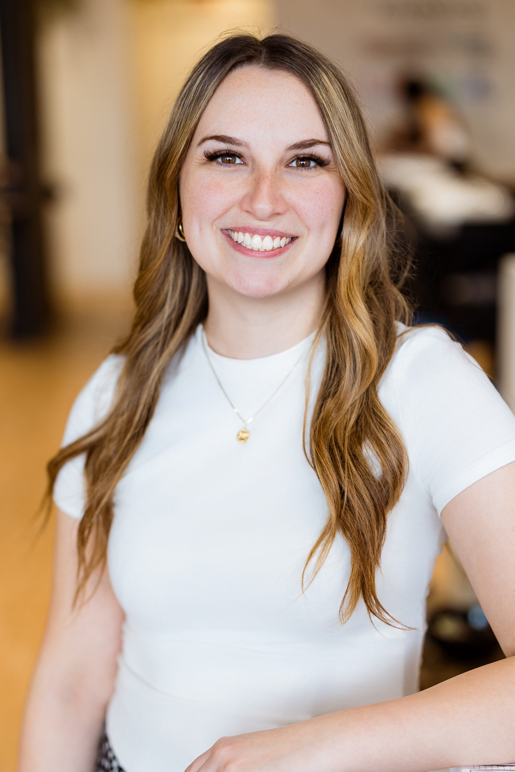 Femme avec cheveux ondulés, vêtue en blanc.