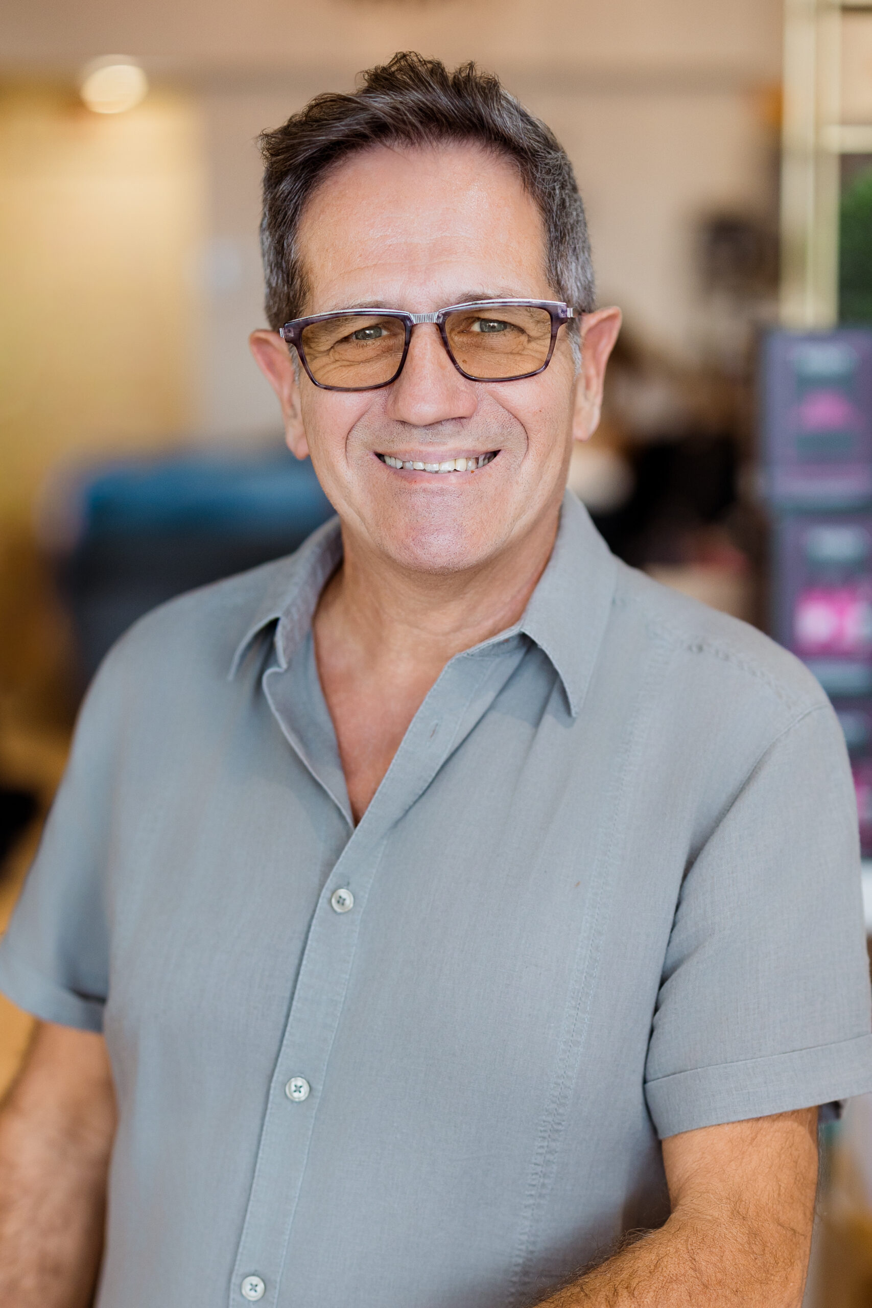 Homme en chemise grise, intérieur.