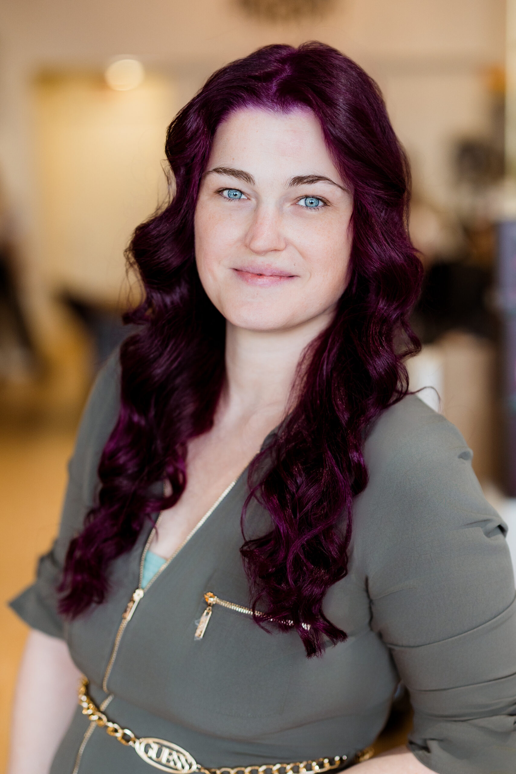 Femme aux cheveux violets ondulés.