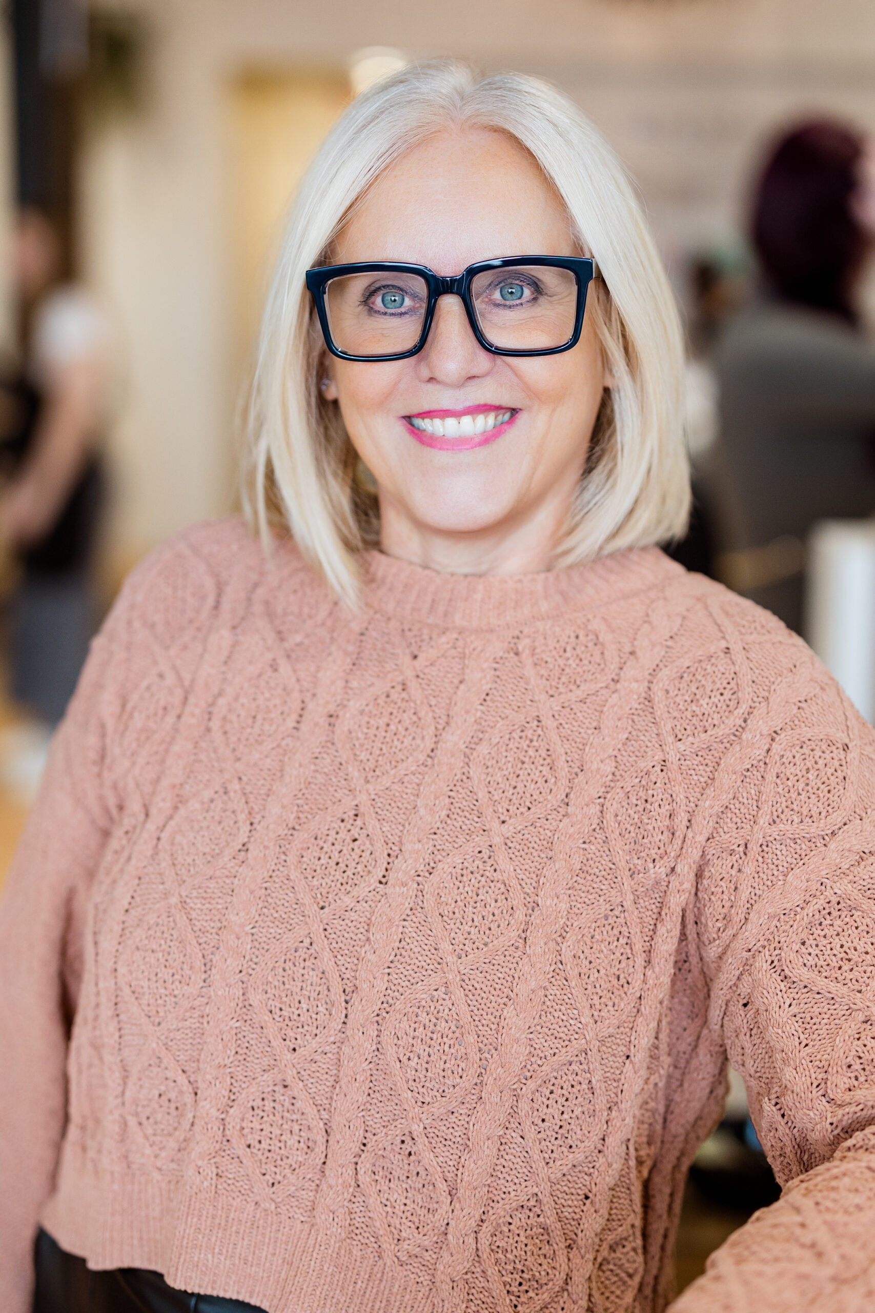 Femme avec un pull rose clair.
